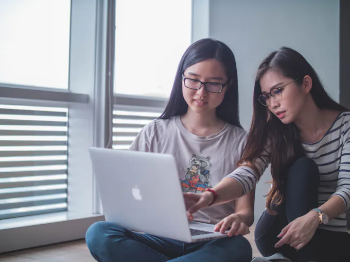 Two women collaborating on a laptop